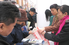 中國質(zhì)量檢驗協(xié)會工作人員在2006年“3.15”咨詢活動現(xiàn)場向消費者發(fā)放資料
